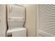 Efficient laundry area with stacked washer and dryer unit and shelving at 1945 Gulf Of Mexico Dr # M2-516, Longboat Key, FL 34228