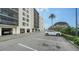 Parking area by condo building featuring covered parking and landscaping at 1945 Gulf Of Mexico Dr # M2-516, Longboat Key, FL 34228