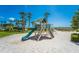 Beachside playground with a slide, swings, and climbing features, nestled among palm trees at 1945 Gulf Of Mexico Dr # M2-516, Longboat Key, FL 34228