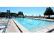 A large, crystal-clear swimming pool is surrounded by lounge chairs and umbrellas on a sunny day at 1945 Gulf Of Mexico Dr # M2-516, Longboat Key, FL 34228