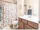 Traditional bathroom with a floral shower curtain, a light wood vanity and countertop, and a framed mirror at 19962 Benissimo Dr, Venice, FL 34293
