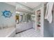 Bathroom with walk-in shower, double sinks, white cabinets, and built-in shelving for storage at 215 Santarem Cir, Punta Gorda, FL 33983