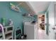 Well lit laundry room features white appliances, shelving, and storage racks for organization at 215 Santarem Cir, Punta Gorda, FL 33983