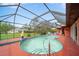 Screened-in pool area with view of the yard, blue tile trim and an array of seating arrangements at 215 Santarem Cir, Punta Gorda, FL 33983