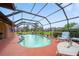 Screened-in pool area surrounded by lush landscaping with seating, pool equipment, and house views at 215 Santarem Cir, Punta Gorda, FL 33983