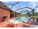 Screened-in pool and patio area with outdoor seating, grill, and a sun-themed wall decoration at 215 Santarem Cir, Punta Gorda, FL 33983