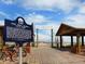 Anna Maria City Pier entrance featuring a historical marker and wooden boardwalk leading towards the ocean at 217 Spring Ave, Anna Maria, FL 34216