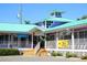 Colorful commercial building with a teal roof, white railings, and a welcoming entrance at 217 Spring Ave, Anna Maria, FL 34216