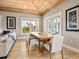 Bright dining room with wood ceiling, wood floors, large windows, and a wooden table with seating for six at 217 Spring Ave, Anna Maria, FL 34216