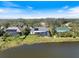 A home with a screened pool sits on a manicured lawn and pond at 28 Dominica Dr, Englewood, FL 34223