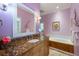 Granite vanity and large mirror in a bathroom with a soaking tub and tiled floor at 28 Dominica Dr, Englewood, FL 34223