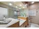 Well-lit bathroom featuring double vanity with marble countertops and decorative accents at 28 Dominica Dr, Englewood, FL 34223