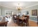 Traditional dining room featuring a wooden table, decorative chandelier, and access to the lanai at 28 Dominica Dr, Englewood, FL 34223