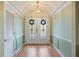 Inviting foyer with decorative glass front doors and hardwood floors at 28 Dominica Dr, Englewood, FL 34223