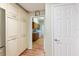 Hallway leading into a laundry room with storage cabinets and wood-look floors at 28 Dominica Dr, Englewood, FL 34223