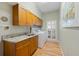 Functional laundry room with wooden cabinets, granite countertops, and modern appliances at 28 Dominica Dr, Englewood, FL 34223