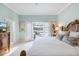 Light and bright main bedroom with a king bed, shuttered doors and a view of the patio at 28 Dominica Dr, Englewood, FL 34223