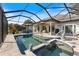 A screened-in pool and spa offer a relaxing retreat with a view of the backyard at 28 Dominica Dr, Englewood, FL 34223