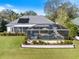 Aerial view of the pool and spa in a screened enclosure, surrounded by a landscaped backyard at 28 Dominica Dr, Englewood, FL 34223
