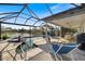 Inviting screened-in pool area with spa, covered seating area, and lake view at 28 Dominica Dr, Englewood, FL 34223