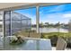 Enjoy lake views from the screened-in porch with dining table at 28 Dominica Dr, Englewood, FL 34223
