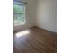 Bright bedroom featuring wood-look floors, a window, and neutral paint at 3722 S Cranberry Blvd, North Port, FL 34286