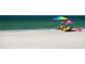 Bright beach scene with white sands, turquoise water, beach umbrellas and people at 3864 Chatsworth Greene Ct # 10, Sarasota, FL 34235