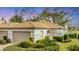 Charming villa featuring a tan-tiled roof, stucco exterior, two-car garage, and meticulous landscaping at 3864 Chatsworth Greene Ct # 10, Sarasota, FL 34235