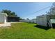 Large backyard featuring a storage shed, pool with screen, and lush green grass at 4210 Pandora Rd, Venice, FL 34293