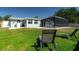 Expansive backyard featuring a screened-in pool area, lush lawn, and comfortable lounge chairs at 4210 Pandora Rd, Venice, FL 34293