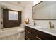 Modern bathroom featuring double sinks, stylish fixtures, and a tiled shower with a large window at 4210 Pandora Rd, Venice, FL 34293