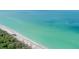 Stunning coastal view highlighting the white sandy beach meeting the clear turquoise ocean at 4210 Pandora Rd, Venice, FL 34293