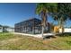 The backyard features a screened-in pool, a tropical palm tree, and a seating area at 4210 Pandora Rd, Venice, FL 34293