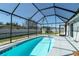 Enclosed swimming pool with modern screened-in enclosure and ladder for easy access at 4210 Pandora Rd, Venice, FL 34293