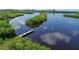 Scenic waterfront view featuring lush mangroves, calm water, and a private wooden dock, ideal for boating at 4210 Pandora Rd, Venice, FL 34293