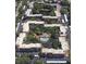 Aerial view of the building complex featuring mature trees and a community pool and pond at 435 30Th W Ave # D303, Bradenton, FL 34205