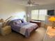 Comfortable bedroom with a ceiling fan, a large window with blinds, and matching nightstands and lamps at 435 30Th W Ave # D303, Bradenton, FL 34205