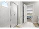 Modern bathroom with a glass-enclosed shower, marble tile, and a view into the bedroom at 44325 Saddlewood Ct, Punta Gorda, FL 33982