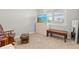 Bright bedroom features large window with shutters, carpeted floors, rocking chair, and a bench at 44325 Saddlewood Ct, Punta Gorda, FL 33982
