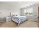 Serene bedroom with a queen bed, tray ceiling, and a view of the outside through plantation shutters at 44325 Saddlewood Ct, Punta Gorda, FL 33982