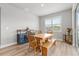 Bright dining area with wooden table, bench, cabinet, and large window with plantation shutters at 44325 Saddlewood Ct, Punta Gorda, FL 33982