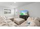 Bright living room showcasing a comfortable sectional sofa, large TV, and plantation shutters at 44325 Saddlewood Ct, Punta Gorda, FL 33982