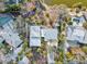 Bird's-eye view of a home with a light-colored roof surrounded by lush landscaping and nearby pond at 4710 Gleason Ave, Sarasota, FL 34242