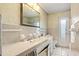 Bathroom featuring double sinks, tile countertop and walls, and framed mirror at 4710 Gleason Ave, Sarasota, FL 34242