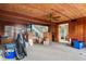 Living room with wood-paneled walls, a ceiling fan, and natural light filtering through the windows at 4710 Gleason Ave, Sarasota, FL 34242