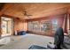 Spacious living room with wood-paneled walls, a ceiling fan, and natural light filtering through the windows at 4710 Gleason Ave, Sarasota, FL 34242