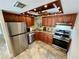 Updated kitchen with granite countertops, tile flooring, stainless steel appliances, and warm wood cabinets at 500 N Osceola Ave # 203, Clearwater, FL 33755