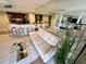 Open-concept living area features a sleek couch, mirrored wall, and breakfast bar leading to the kitchen at 500 N Osceola Ave # 203, Clearwater, FL 33755
