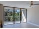 Bright living room featuring a ceiling fan, sliding glass doors and a view of the surrounding nature at 500 N Osceola Ave # 203, Clearwater, FL 33755