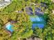 An aerial view shows a community pool, tennis courts, lush landscaping, and parking for residents' convenience at 5714 Garden Lakes Fern, Bradenton, FL 34203